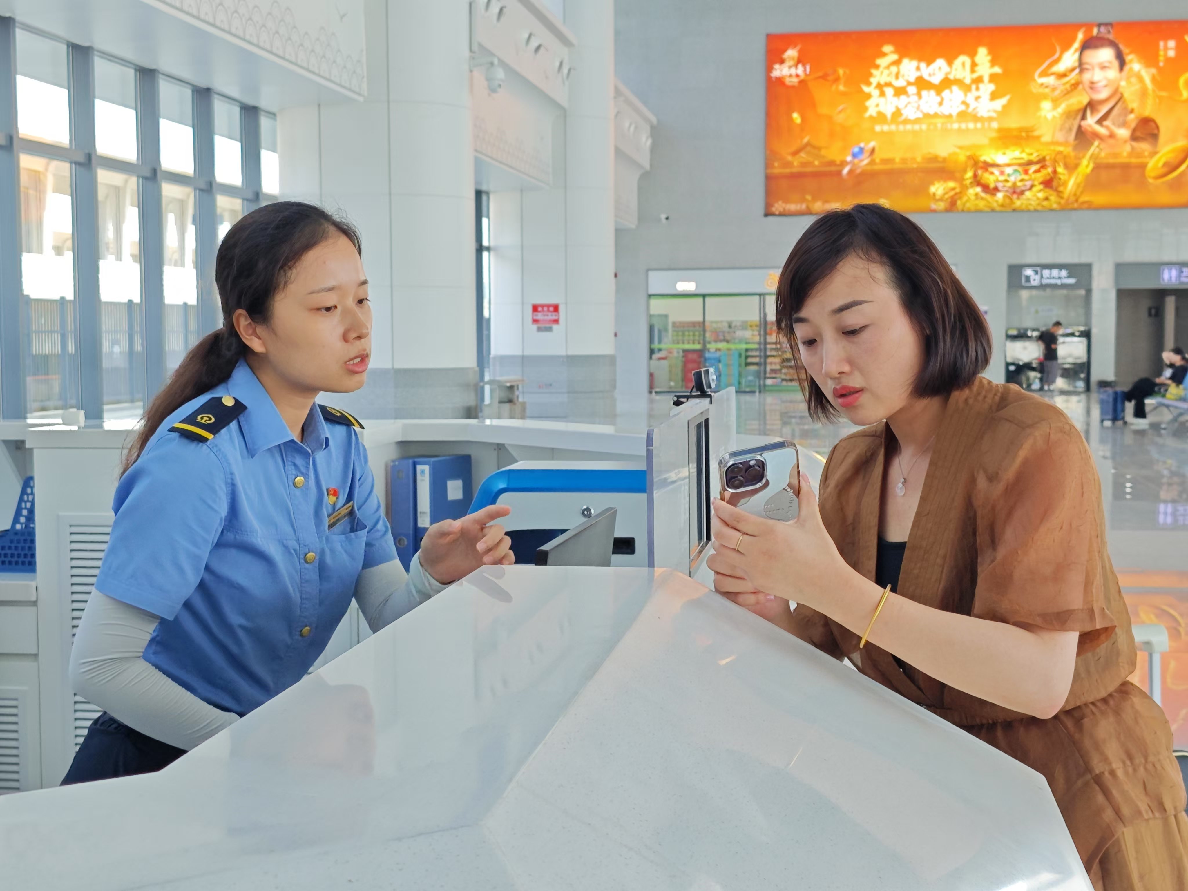 鄱陽站服務(wù)臺的工作人員在為旅客解答疑惑。余清清 攝.jpg